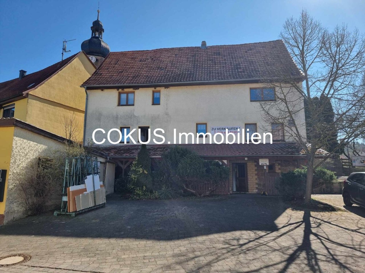 Haus von vorne mit Parkplätzen Haus von vorne mit Parkplätzen